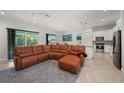 Spacious living room featuring a large leather sectional sofa and access to kitchen at 3302 Palm Dr, Punta Gorda, FL 33950