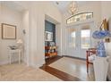A lovely foyer features a decorative light fixture, tile flooring, and glass front doors at 3353 Sandpiper Dr, Punta Gorda, FL 33950