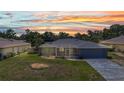 Home with a screened patio and lush green lawn viewed at sunset at 336 Waterside St, Port Charlotte, FL 33954