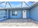 Tiled screened patio with a white entry door and view of the backyard at 336 Waterside St, Port Charlotte, FL 33954