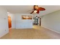 Bright living room featuring tile flooring, a modern ceiling fan, and views into the kitchen and lanai at 4071 Dekle Ave, North Port, FL 34286