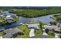 Panoramic aerial view of a waterfront home surrounded by lush greenery and waterways, with a neatly kept lawn at 4216 Bur St, Port Charlotte, FL 33948