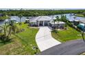Aerial view of property with a spacious lawn, long driveway, and waterfront views of the canal at 4216 Bur St, Port Charlotte, FL 33948