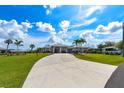 Lovely property showcasing a well-manicured lawn, circular driveway, and the home's unique architectural details at 4216 Bur St, Port Charlotte, FL 33948