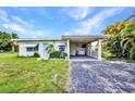 Front exterior of home featuring a carport, tropical plants, and a blue door at 426 Burland St, Punta Gorda, FL 33950