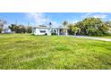 Charming single-story home surrounded by lush greenery and a well-maintained lawn at 426 Burland St, Punta Gorda, FL 33950