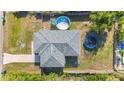 An aerial view of a home with a lush backyard featuring a pool, trampoline, and a spacious driveway at 4702 Westwood Dr, Punta Gorda, FL 33982