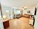 Inviting living room with tile flooring, comfortable seating, ample natural light, and a ceiling fan at 481 Reading Nw St, Port Charlotte, FL 33952