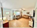 Bright living room featuring tile flooring, comfortable seating, and large windows for natural light at 481 Reading Nw St, Port Charlotte, FL 33952