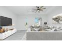Bright living room with modern furniture, recessed lighting, and a ceiling fan at 4862 Kiska Rd, North Port, FL 34288