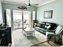 Cozy living room with a comfortable leather sofa, stylish rug, and access to a private balcony at 5114 Melbourne St # A302, Punta Gorda, FL 33980