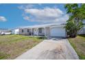 Inviting single-story home with a spacious driveway and neatly landscaped front yard at 6850 S Biscayne Dr, North Port, FL 34287