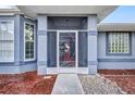 Charming home entry with a screened-in porch and decorative security screen door at 9582 Arsipe Cir, Port Charlotte, FL 33981
