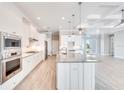 Modern kitchen featuring stainless steel appliances, a spacious island with granite countertops, and ample cabinet space at 15698 Meacham Cir, Port Charlotte, FL 33981