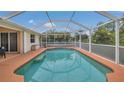 Relaxing screened-in pool featuring blue water and ample space for lounging and entertaining at 1761 Okolona St, North Port, FL 34287
