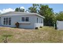 View of the side of the home, showcasing the yard and fencing at 21275 Austin Ave, Port Charlotte, FL 33952