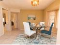 Well-lit dining room featuring a glass table, modern chairs, and tile flooring at 238 Mark Twain Ln, Rotonda West, FL 33947