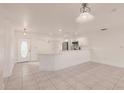 Bright, open-concept living space featuring tile flooring, white walls, and a modern kitchen with stainless steel appliances at 3129 Buttonwood Pl, Punta Gorda, FL 33950