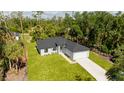 Aerial view of a home with a lush green yard, a private driveway and a manicured lawn at 355 Milton St, Port Charlotte, FL 33954