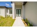 A close-up of the front entrance to the home with a walkway and simple plantings at 355 Milton St, Port Charlotte, FL 33954