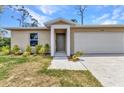 Inviting single-story home with a landscaped front yard, a covered entryway, and an attached two-car garage at 3799 Laredo Ave, North Port, FL 34288