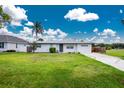 Attractive single-story home featuring lush green lawn and a metal roof at 416 Allen St, Punta Gorda, FL 33950