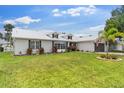 Attractive home boasting a neat lawn, palm trees, dormer windows and a two-car gray garage door at 425 Corrientes Cir, Punta Gorda, FL 33983