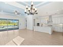 Spacious living area flows into kitchen, boasting white cabinets, an island, and seamless access to the outdoor pool area at 43406 Boardwalk Loop, Punta Gorda, FL 33982