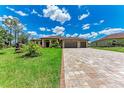 Beautifully landscaped home with a spacious driveway made of decorative pavers at 4380 Maddock Cir, North Port, FL 34286