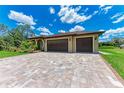 A spacious three-car garage with stylish brown doors complements the home's design at 4380 Maddock Cir, North Port, FL 34286