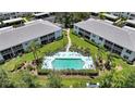 Aerial view of community pool with lounge chairs and tropical landscaping at 5725 Greenwood Ave # 2101, North Port, FL 34287