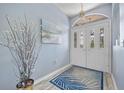 Inviting entryway with decorative glass doors, stylish lighting, and a patterned rug at 7183 Spinnaker Blvd, Englewood, FL 34224