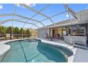Screened-in pool area featuring a spa and outdoor seating, perfect for relaxation at 7183 Spinnaker Blvd, Englewood, FL 34224