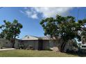 Charming single-story home with a screened entrance and a well-maintained lawn with mature trees at 8158 Trionfo Ave, North Port, FL 34287
