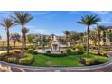 Beautiful community fountain with lush landscaping, mature palms and multi-story buildings in the background at 99 Vivante Blvd # 310, Punta Gorda, FL 33950