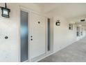 Inviting entrance with classic white door, frosted glass sidelight, and stylish exterior lighting at 1 Colony Point Dr # B20, Punta Gorda, FL 33950
