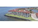 Waterfront condo building with a red tile roof and large windows overlooking the water at 1 Colony Point Dr # B20, Punta Gorda, FL 33950