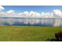 Calm water reflecting a partly cloudy sky; bright green grass in the foreground at 1 Colony Point Dr # B20, Punta Gorda, FL 33950