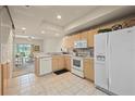 Well-lit kitchen featuring white appliances, wooden cabinets, and an open layout to the dining area at 1236 Rio De Janeiro Ave # 406, Punta Gorda, FL 33983