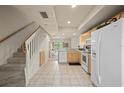 Bright kitchen with tile flooring, white appliances, and seamless access to the dining area at 1236 Rio De Janeiro Ave # 406, Punta Gorda, FL 33983