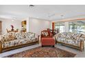 Spacious living room with terrazzo floors, a ceiling fan, and a dining area with a view at 125 Small Se St, Port Charlotte, FL 33952