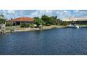Waterfront home featuring a private boat dock, lush landscaping, and serene water views at 1318 San Mateo Dr, Punta Gorda, FL 33950