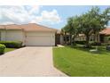 Inviting one-story home featuring a tile roof, brick driveway, and well-maintained lawn, creating a warm curb appeal at 13256 Creekside Ln, Port Charlotte, FL 33953