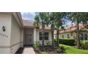 Beautiful single-story home showcasing lush landscaping, a tile roof, and a welcoming brick pathway to the front door at 13256 Creekside Ln, Port Charlotte, FL 33953