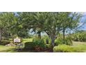 Community entrance featuring a 'Stillwater Trace' sign nestled among lush greenery, offering a serene setting at 13256 Creekside Ln, Port Charlotte, FL 33953