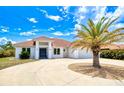 Inviting home featuring a modern front facade, well-manicured landscaping, a circular driveway and a red tile roof at 13295 Eisenhower Dr, Port Charlotte, FL 33953