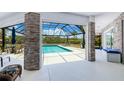 A large screened-in pool area featuring a pool with a view, dining set, grill, and beautiful design elements at 13295 Eisenhower Dr, Port Charlotte, FL 33953