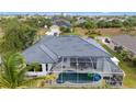 Backyard features screened-in pool, complemented by lush greenery and palm trees, creating a private oasis at 15890 Viscount Cir, Port Charlotte, FL 33981