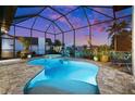 Screened-in pool with a hot tub offers a relaxing outdoor experience at twilight at 1932 Los Alamos Dr, Punta Gorda, FL 33950