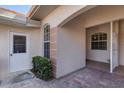 Covered villa entrance with brick floor and neutral walls featuring transom window and sidelight at 2028 Lynx Run, North Port, FL 34288